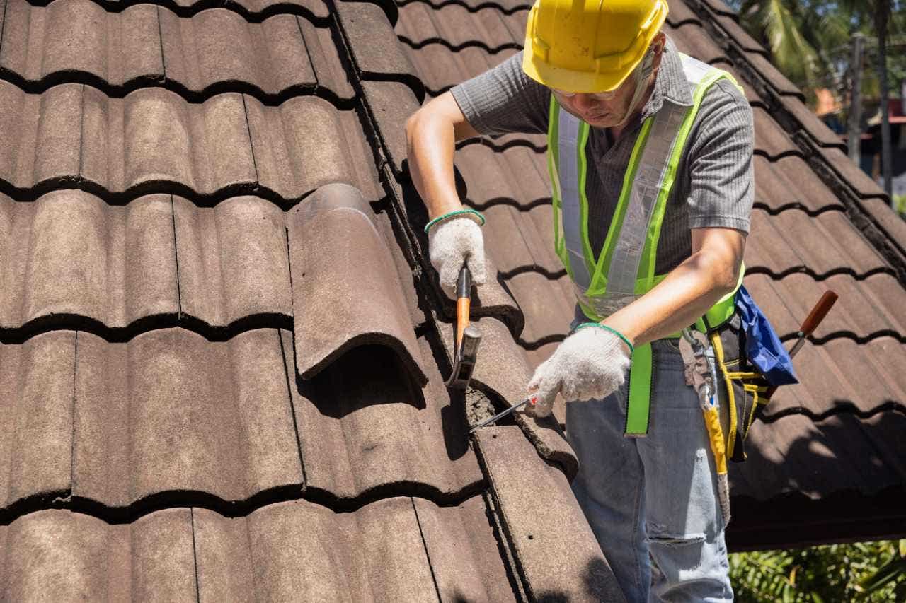 man replacing tile on an old roof