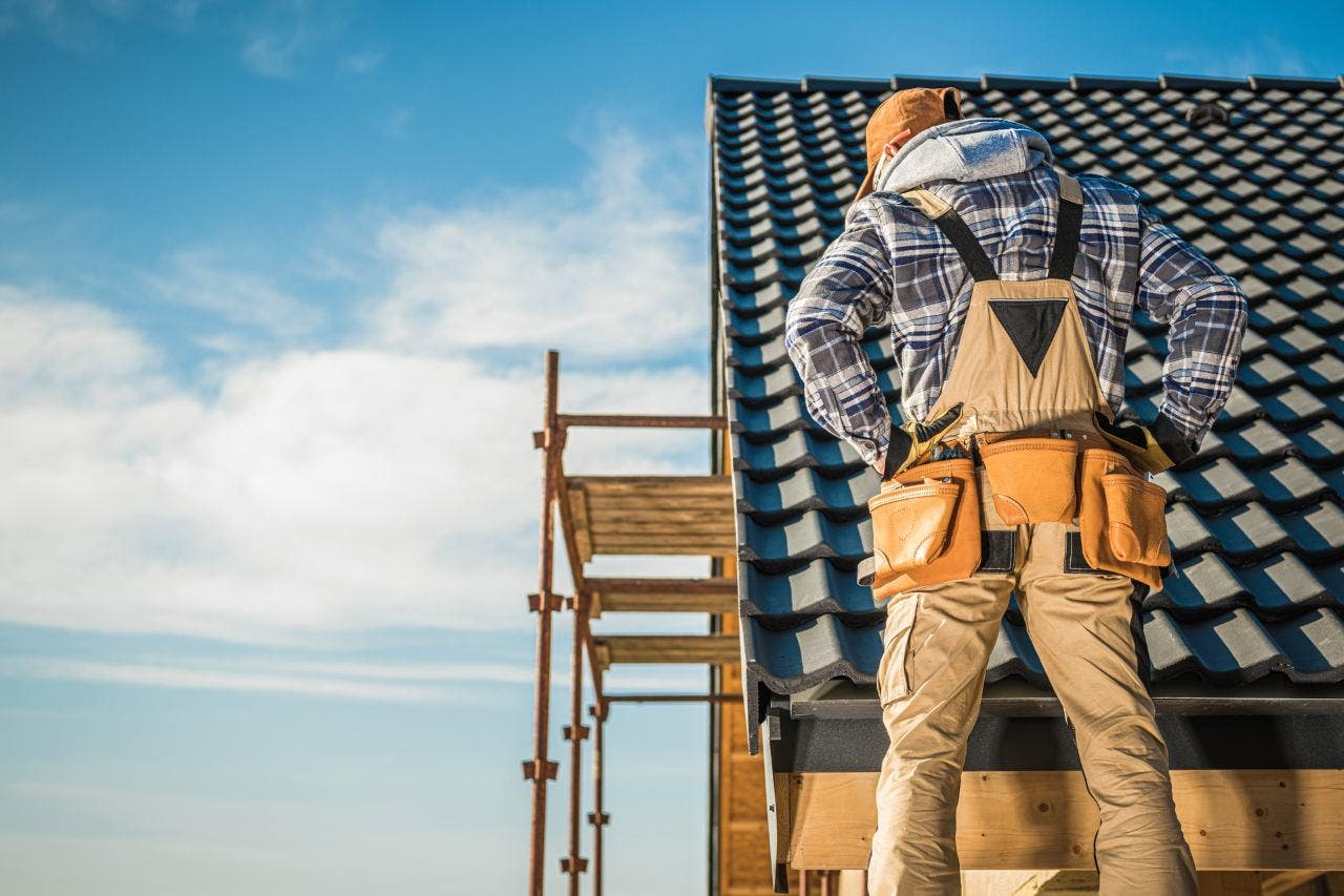 man inspecting a home's tile roof