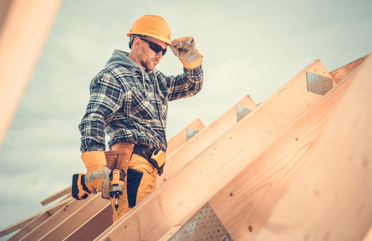 man working on a roof of a newly built house