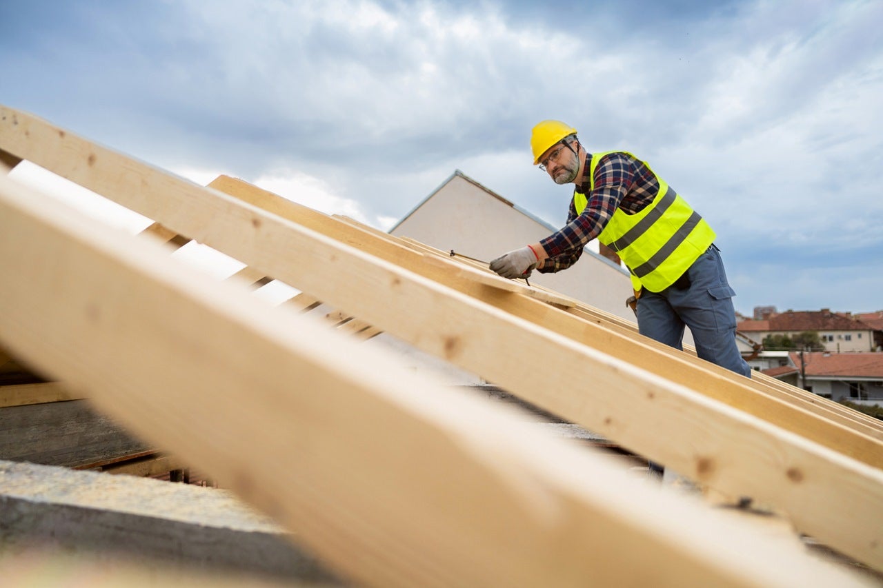 a roofing expert taking measurement of the roof