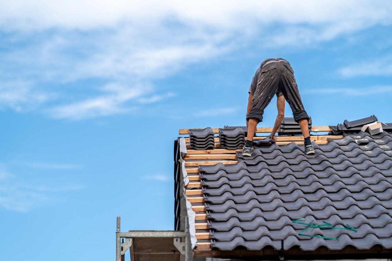 craftsman on the roof of a family house